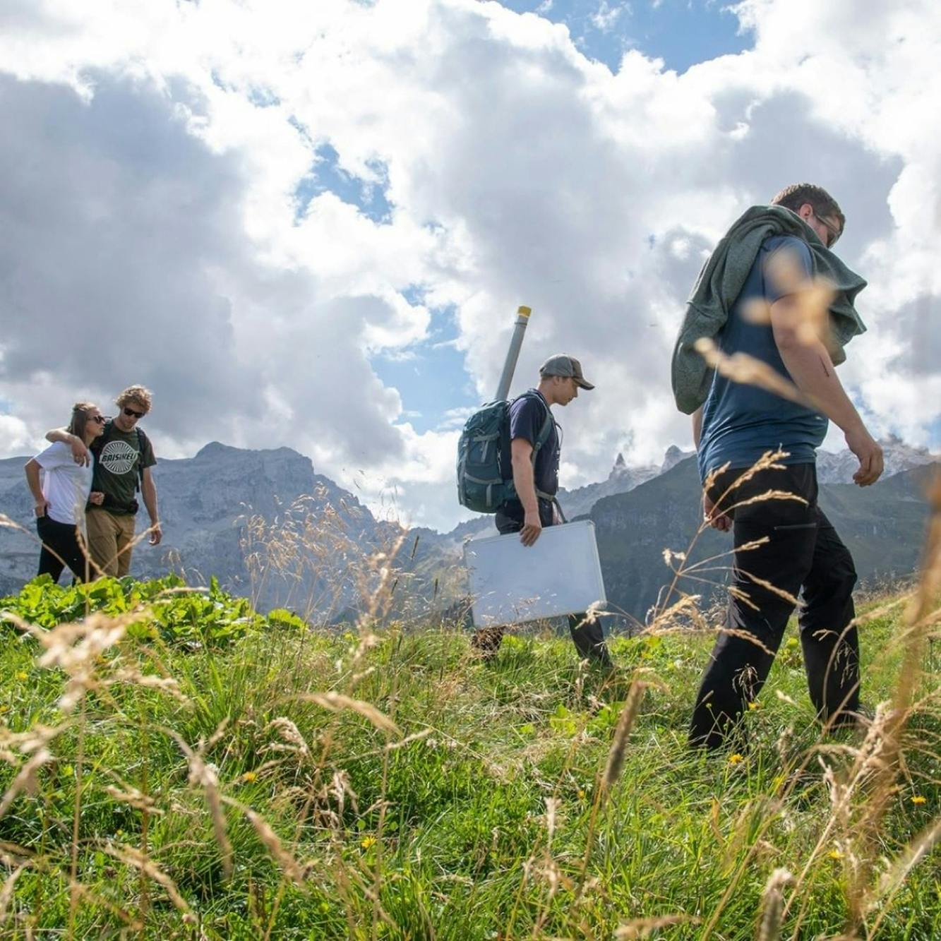Vier Personen laufen durch grüne Wiese am Berg © maray festival
