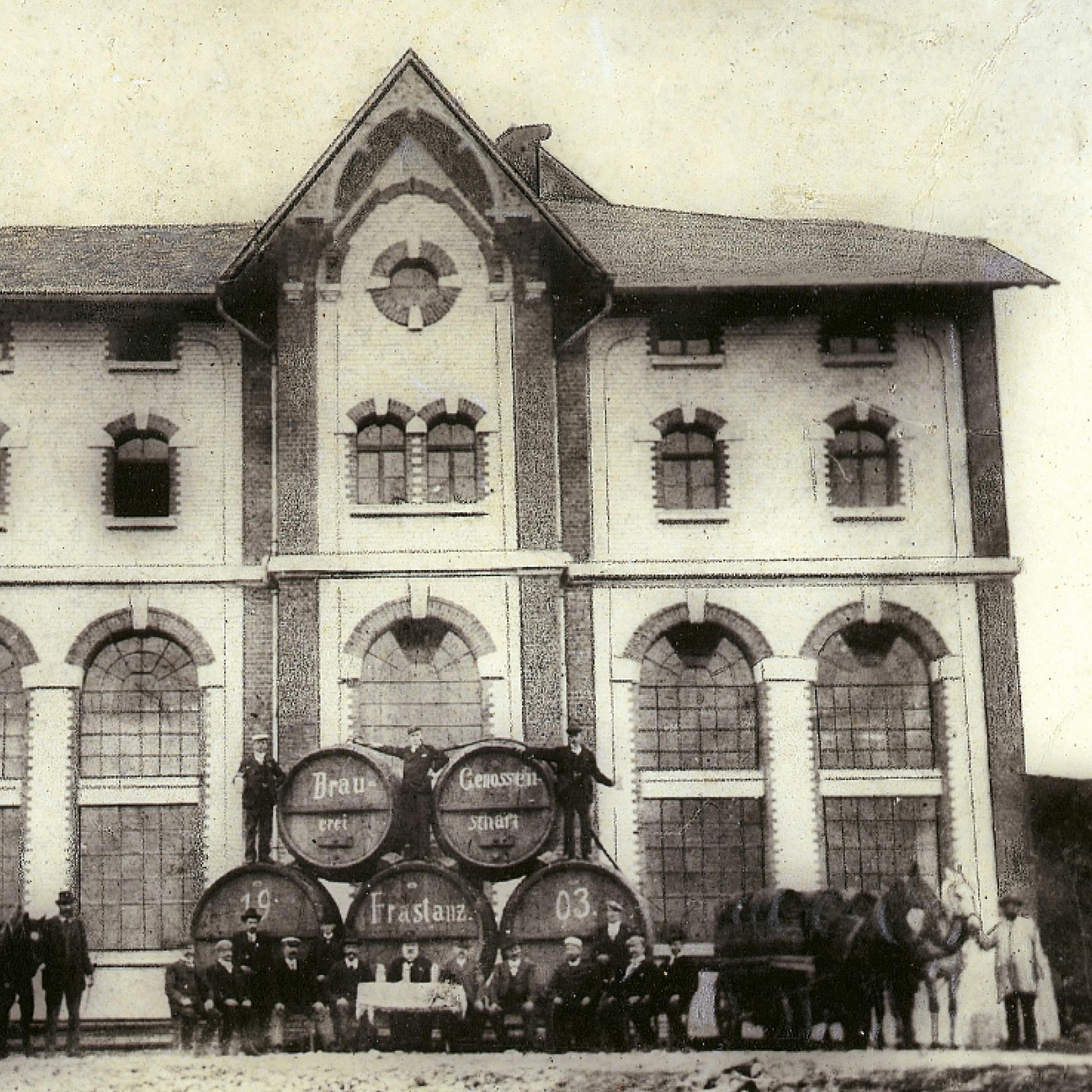 Historisches Foto der Frastanzer Brauerei im Jahr 1903. Bierfässer und Arbeiter vor dem alten Backsteingebäude. © gobiq