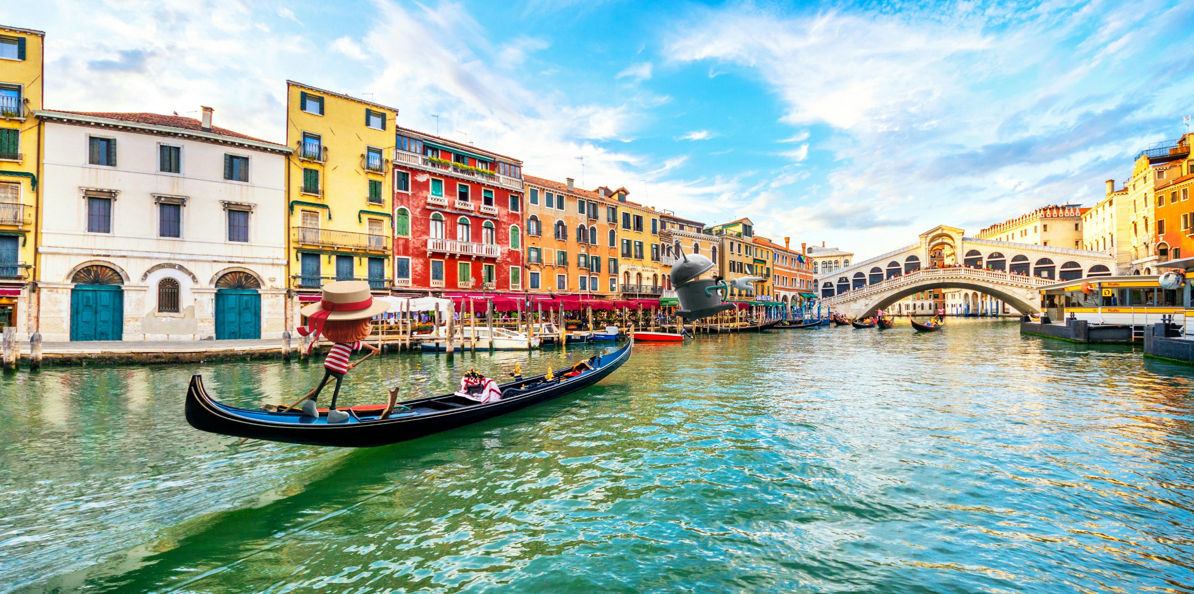 Oskar fährt als Gondoliere eine Gondel durch den Canal Grande in Venedig. Im Hintergrund ist die Rialtobrücke zu sehen, auf die Bo zeigt. © goodmatters